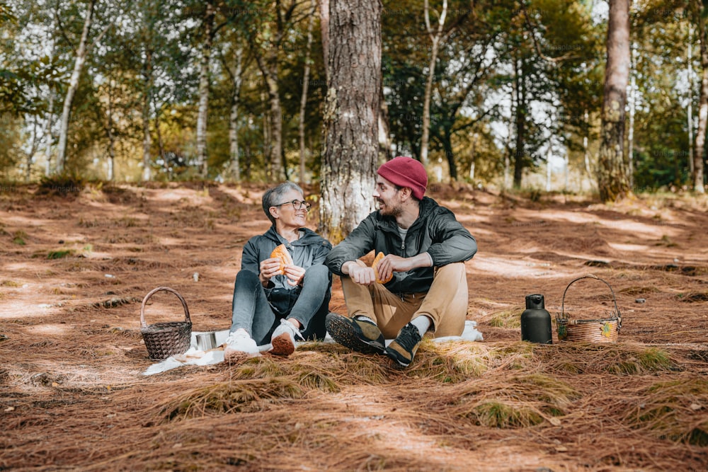 Due uomini seduti a terra nel bosco