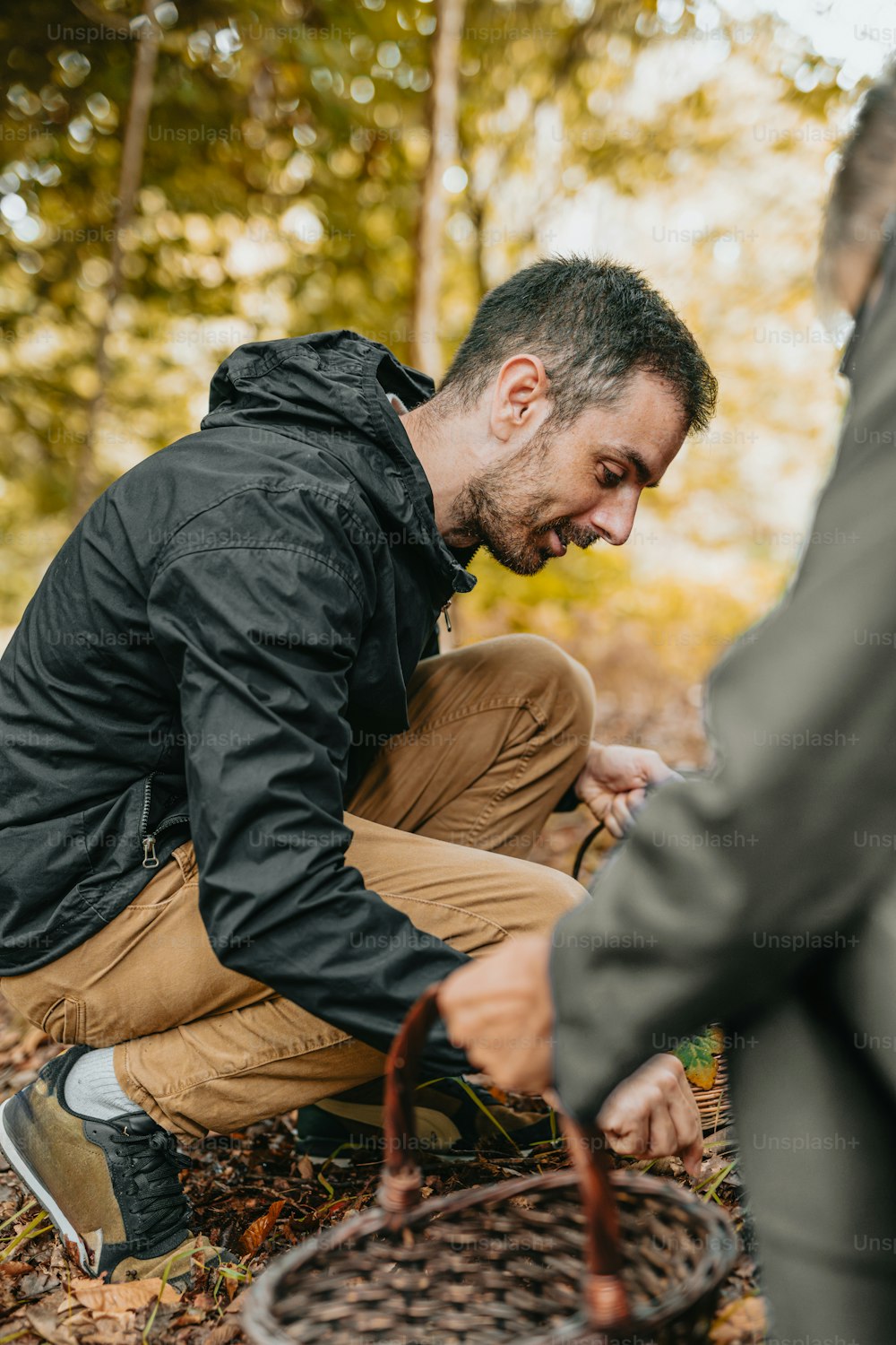 a man kneeling down with a basket in his hand