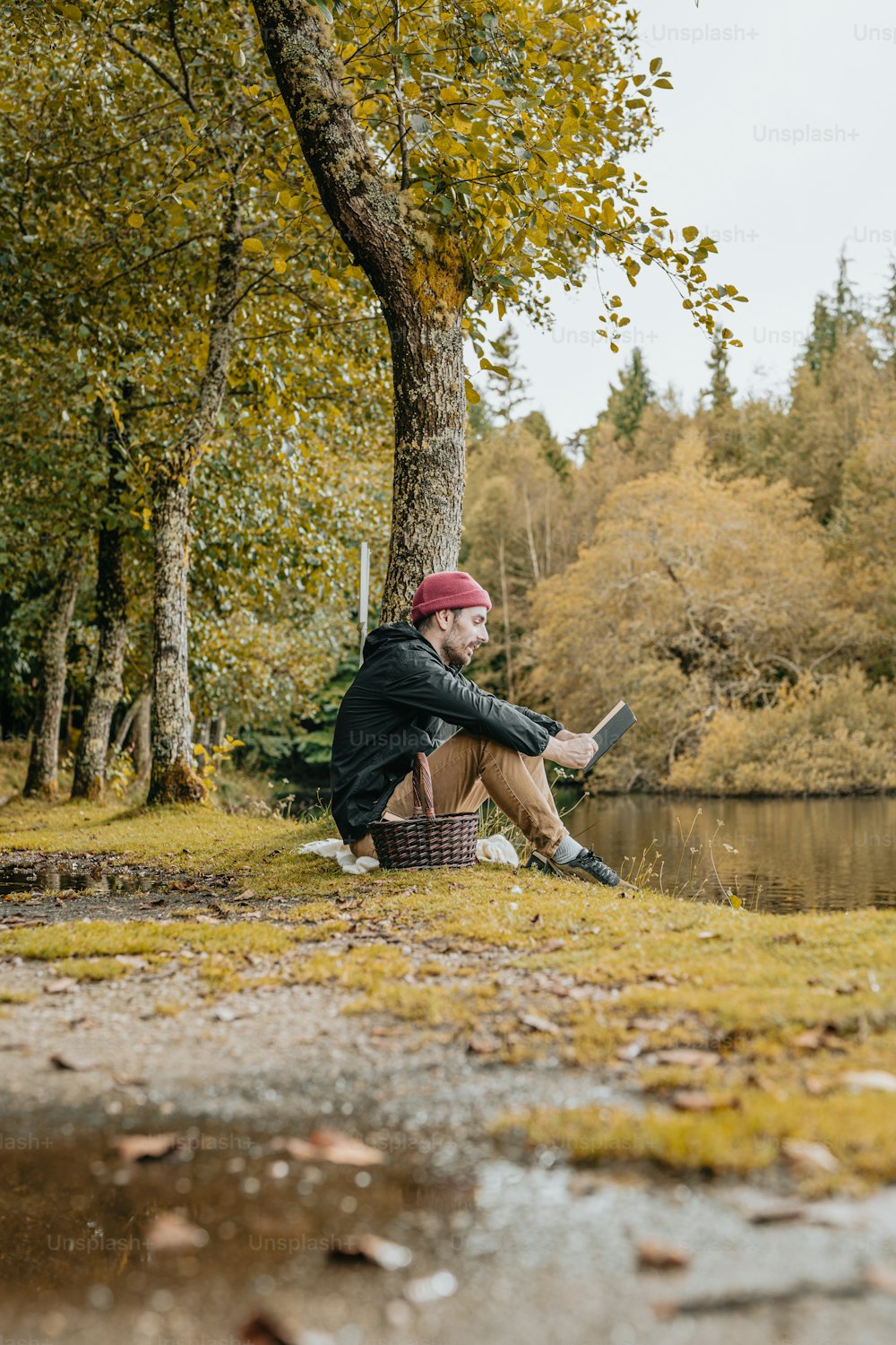 a man sitting on a bench next to a lake
