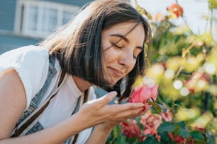 a woman smelling a rose in a garden