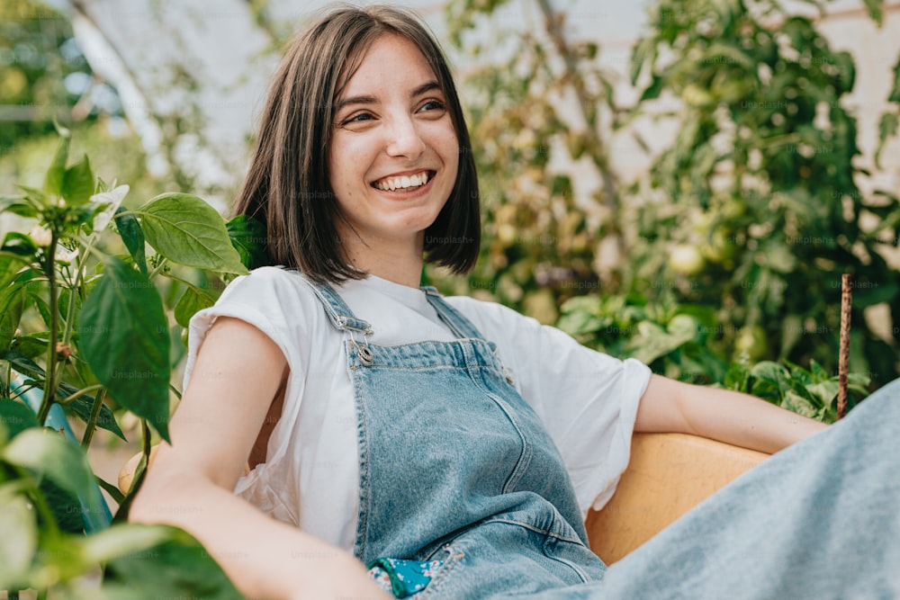 a woman sitting in a chair smiling at the camera