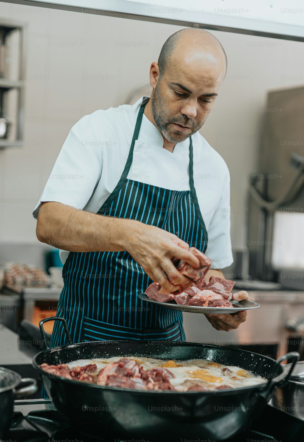 a man in a kitchen preparing food on top of a stove