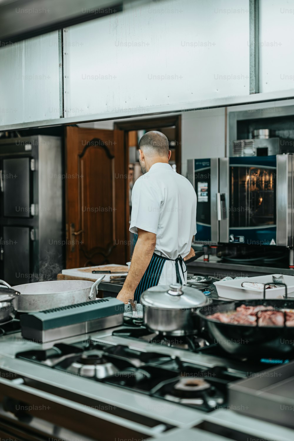 Un uomo in piedi in una cucina che prepara il cibo