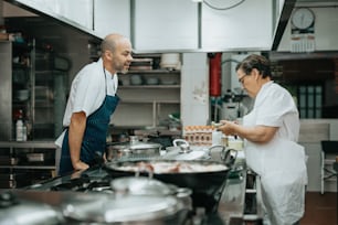 a man and a woman in a kitchen preparing food