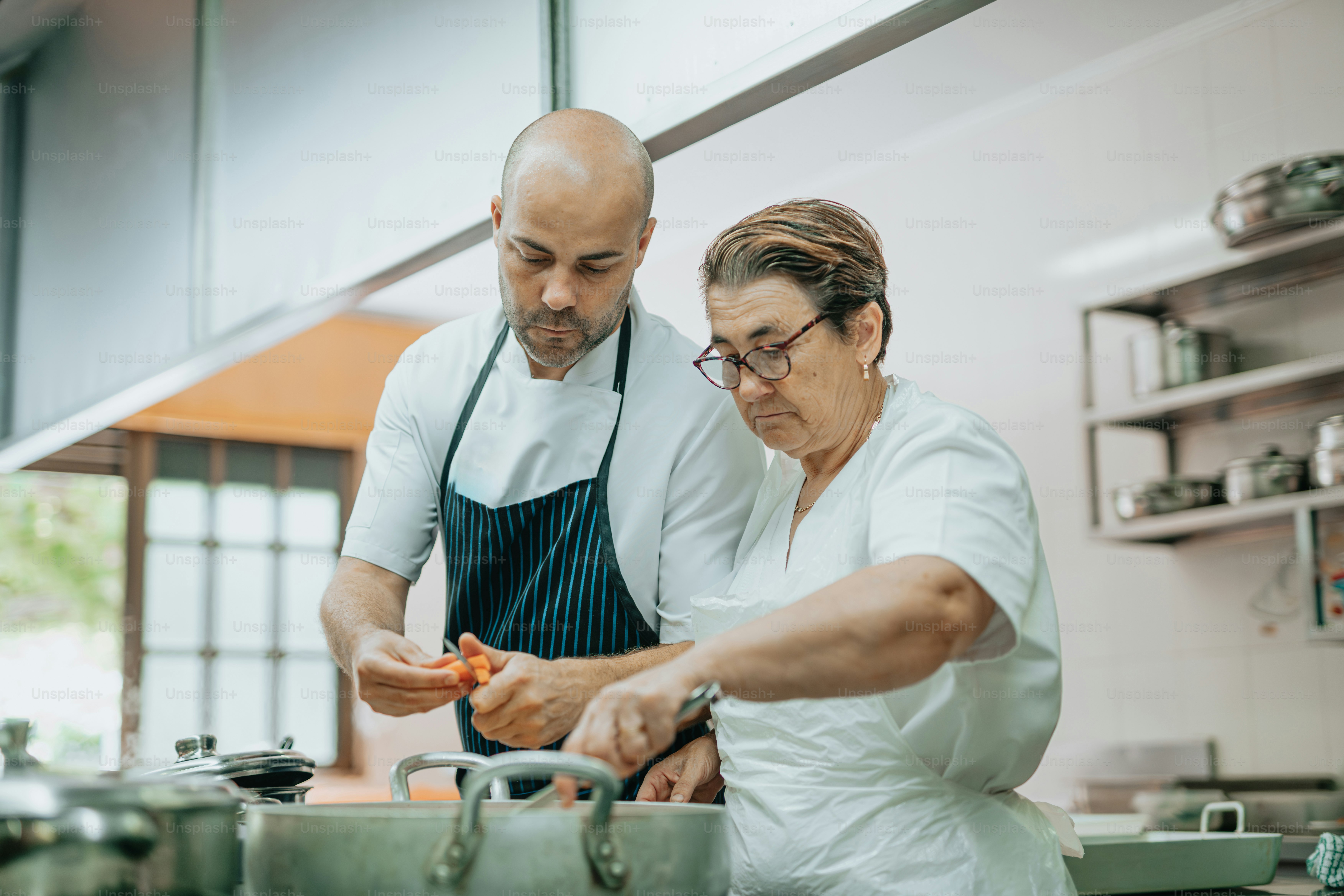 a man and woman in a kitchen preparing food