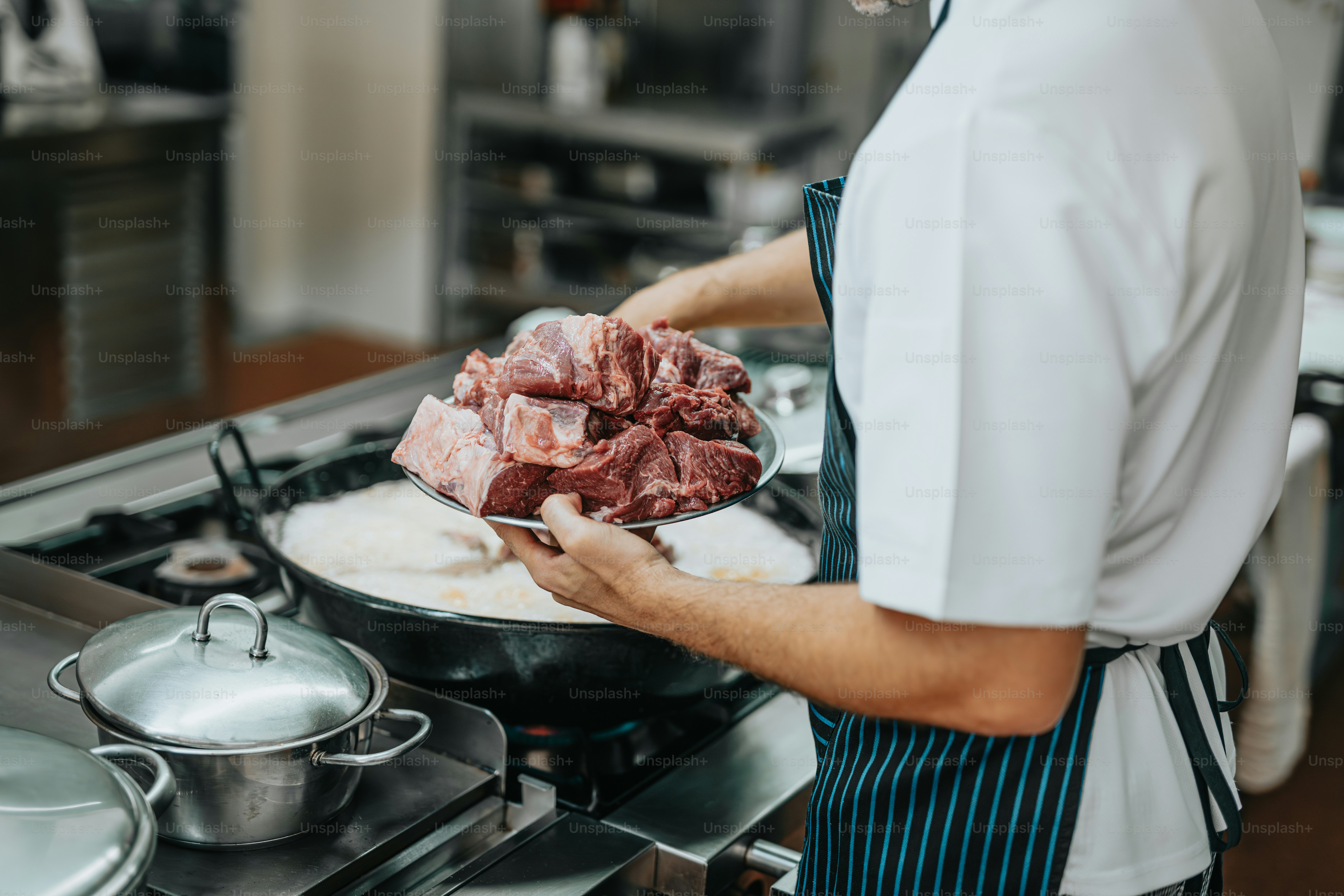 a man in a kitchen preparing food on top of a stove