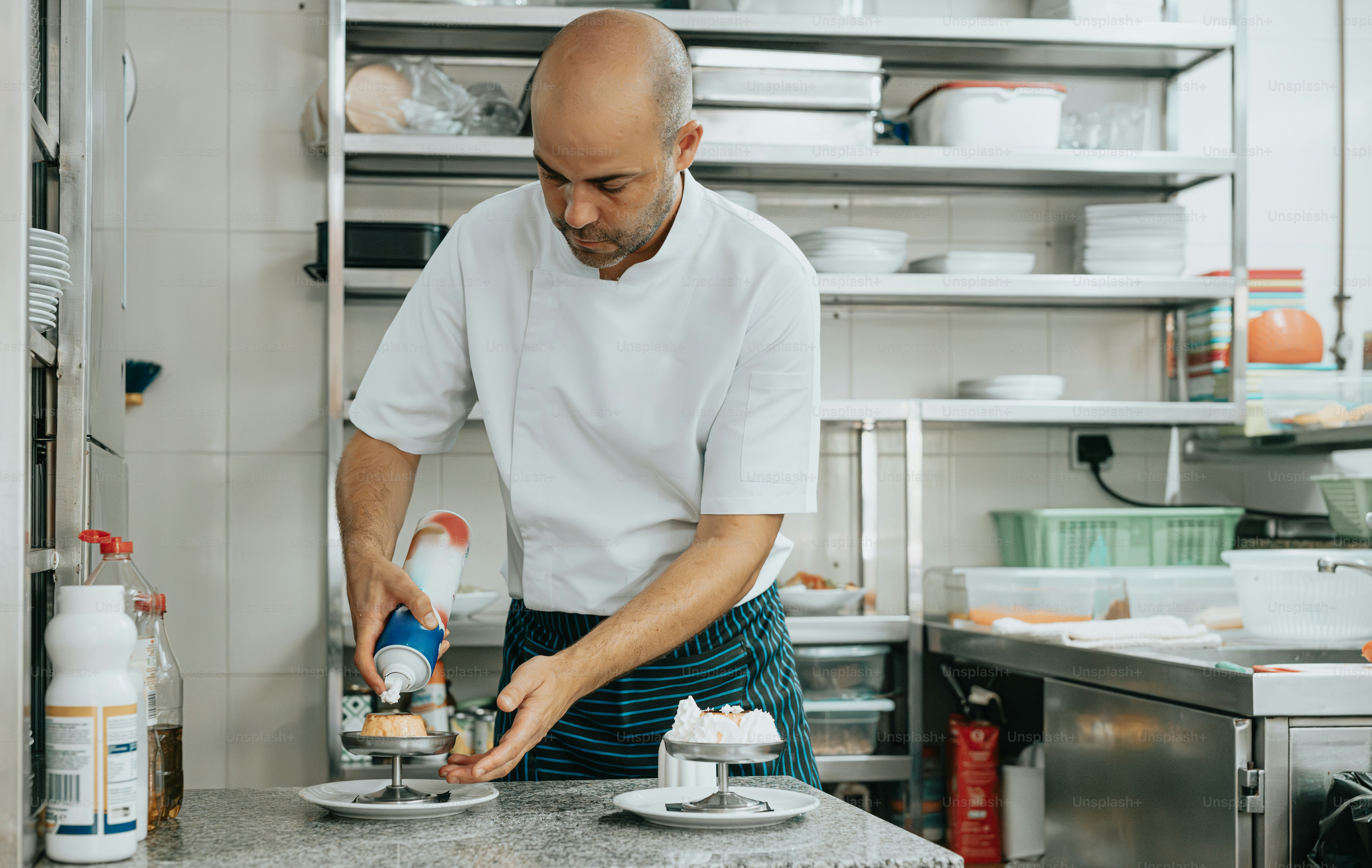 a man in a kitchen preparing food on a plate