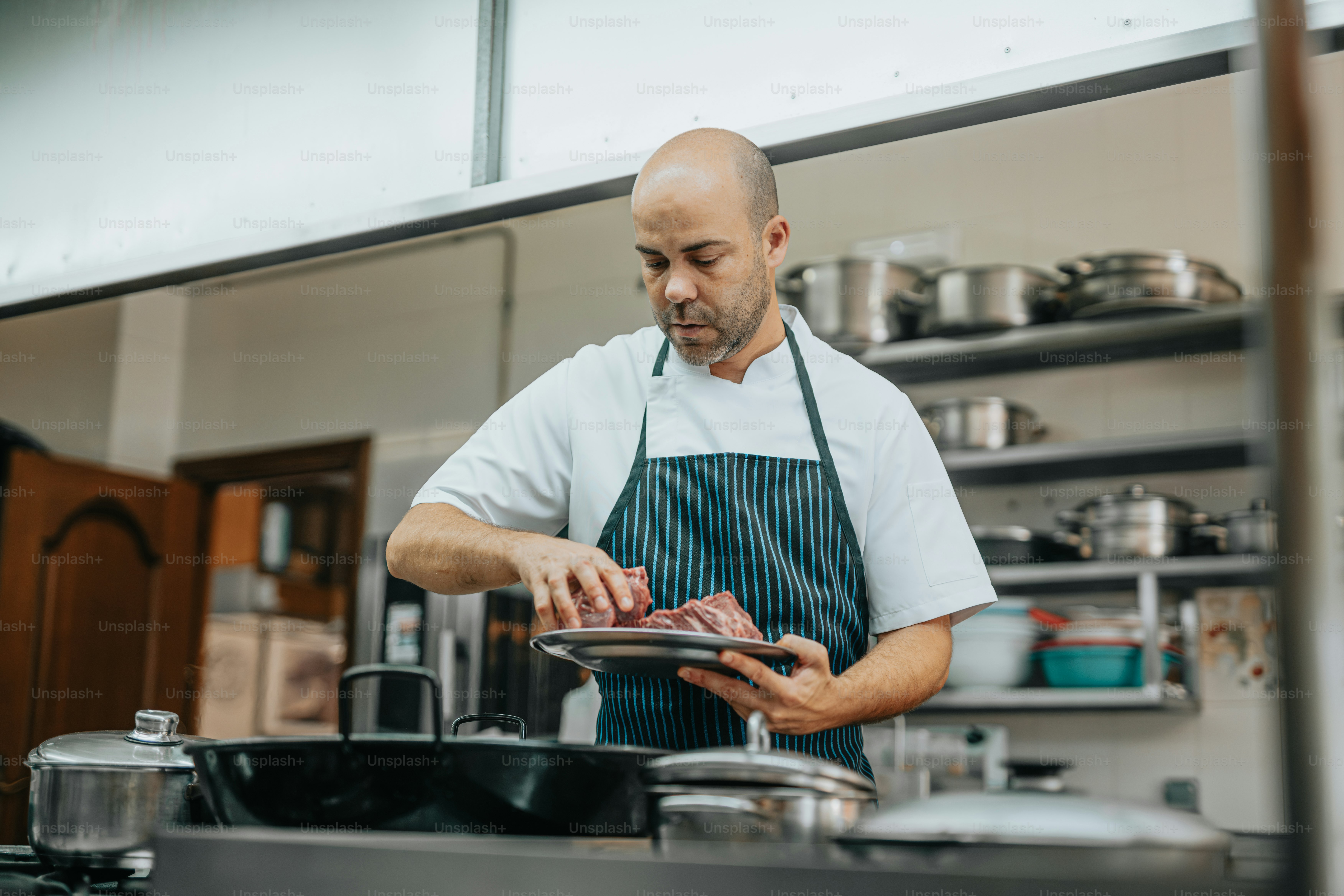 A man standing in a kitchen preparing food photo – Business Image on ...