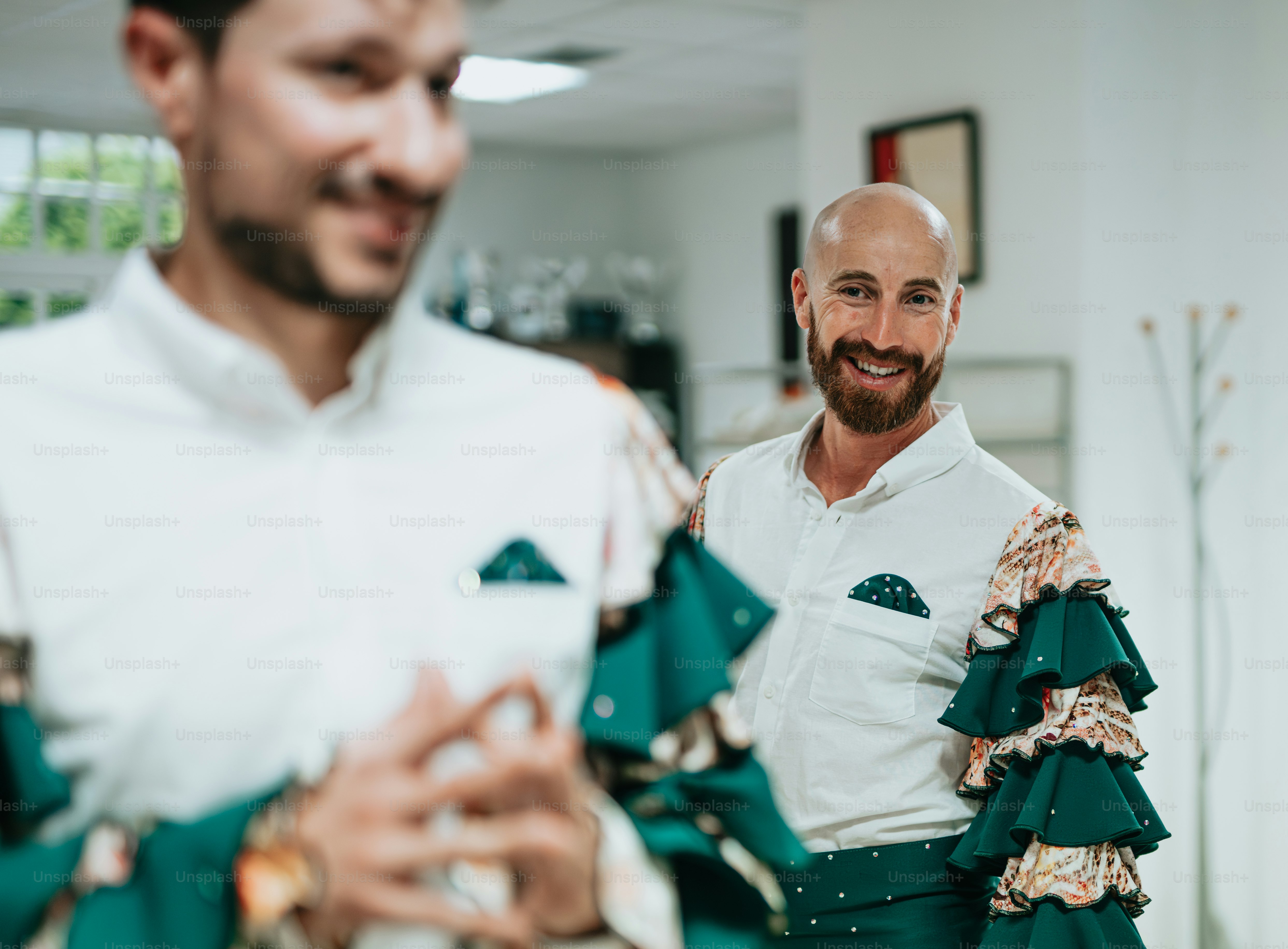 a man in a white shirt and a bald headed man in a green and white