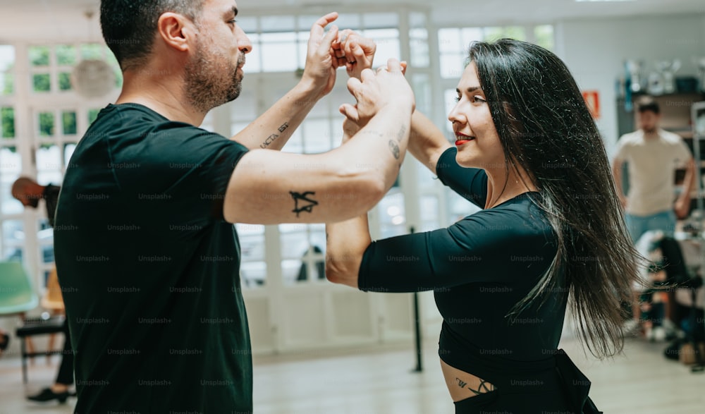 a man and a woman dancing together in a dance studio