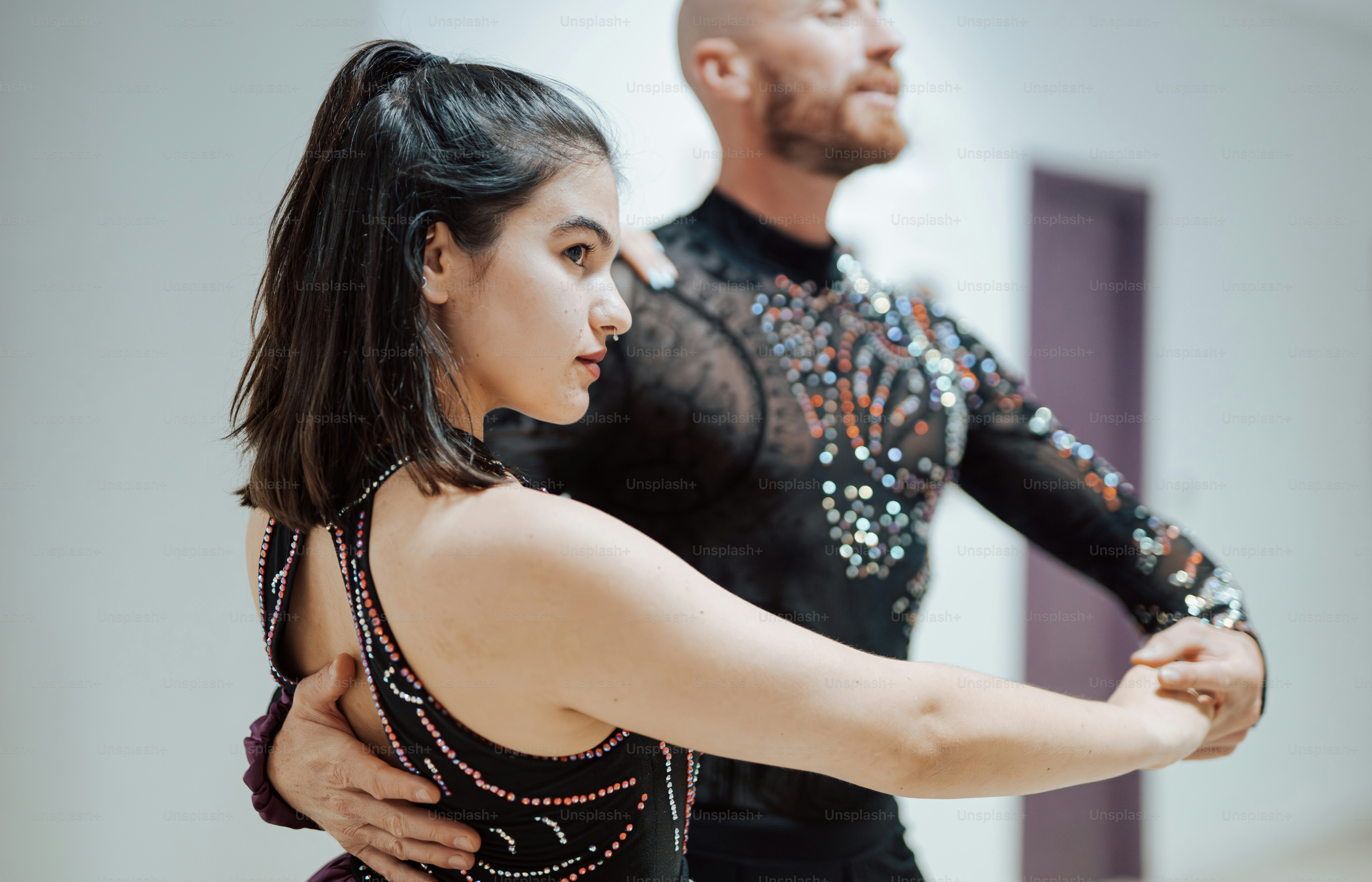a man and a woman dance in a ballroom