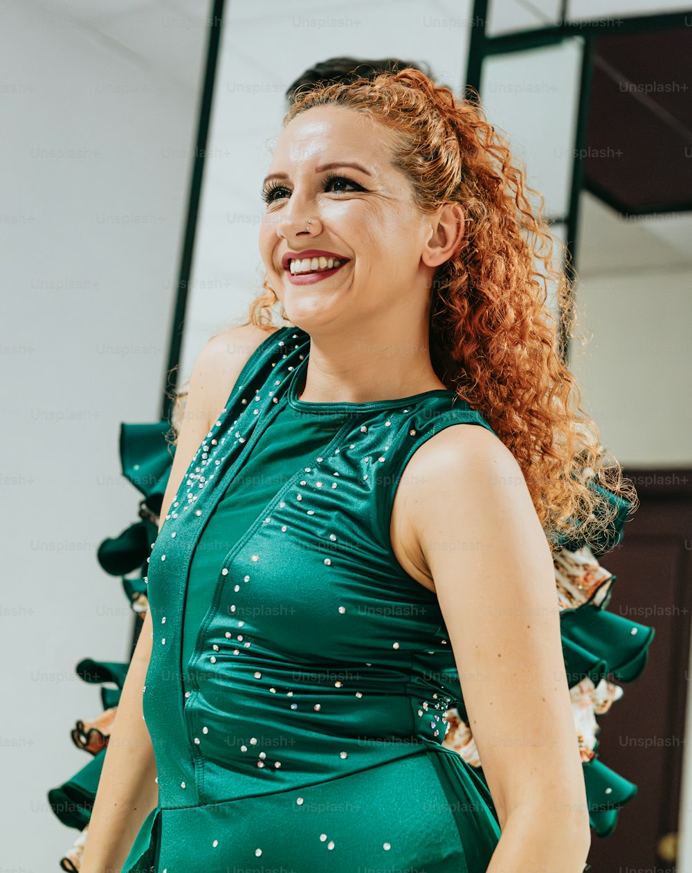 Una mujer con el pelo rojo con un vestido verde