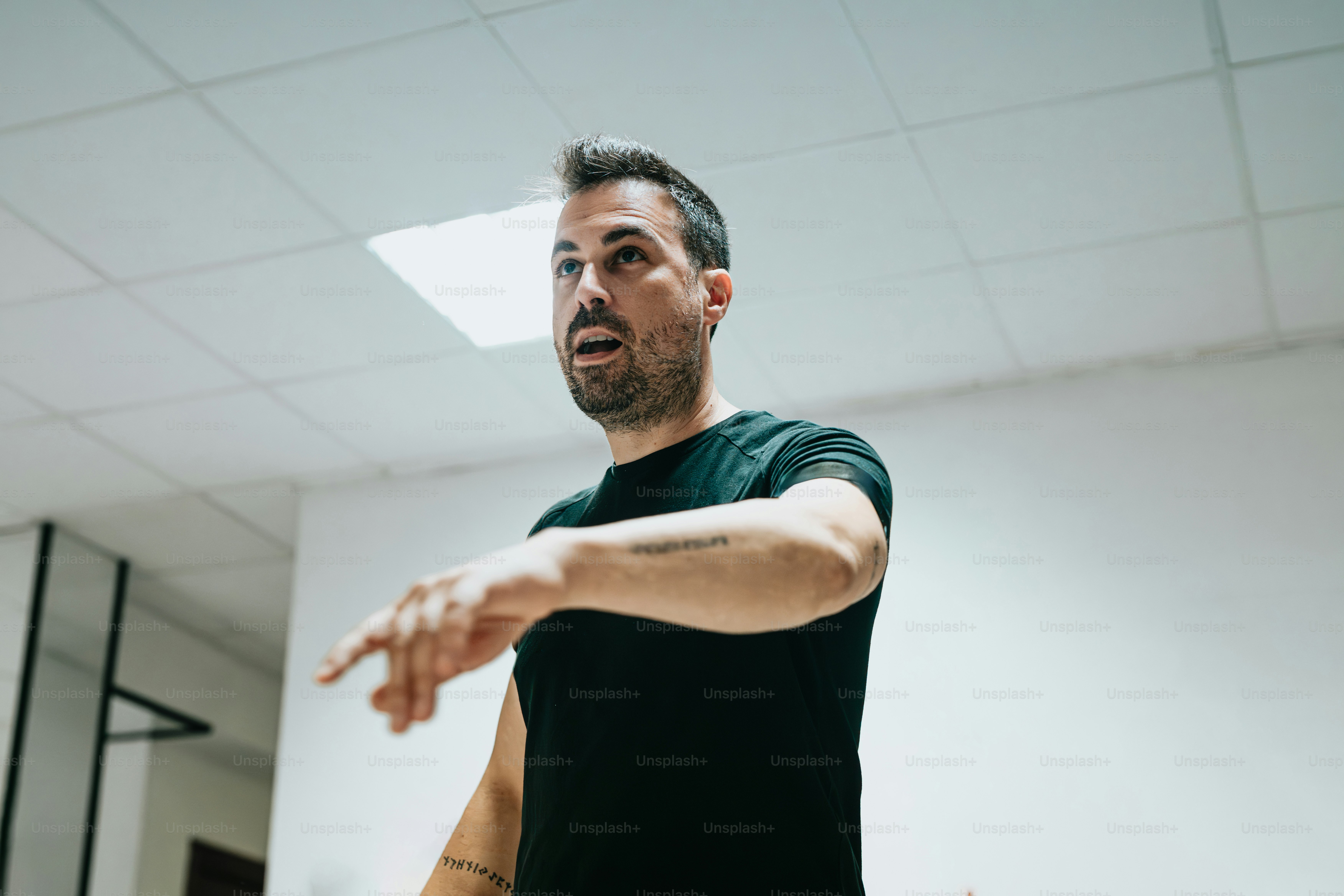 a man in a black shirt is holding a white frisbee