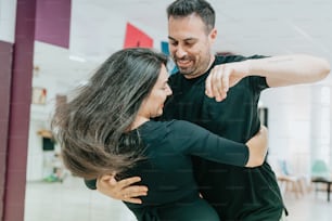 a man and a woman dancing together in a dance studio