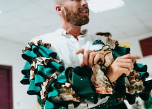 a man in a white shirt and green and white ruffled collar