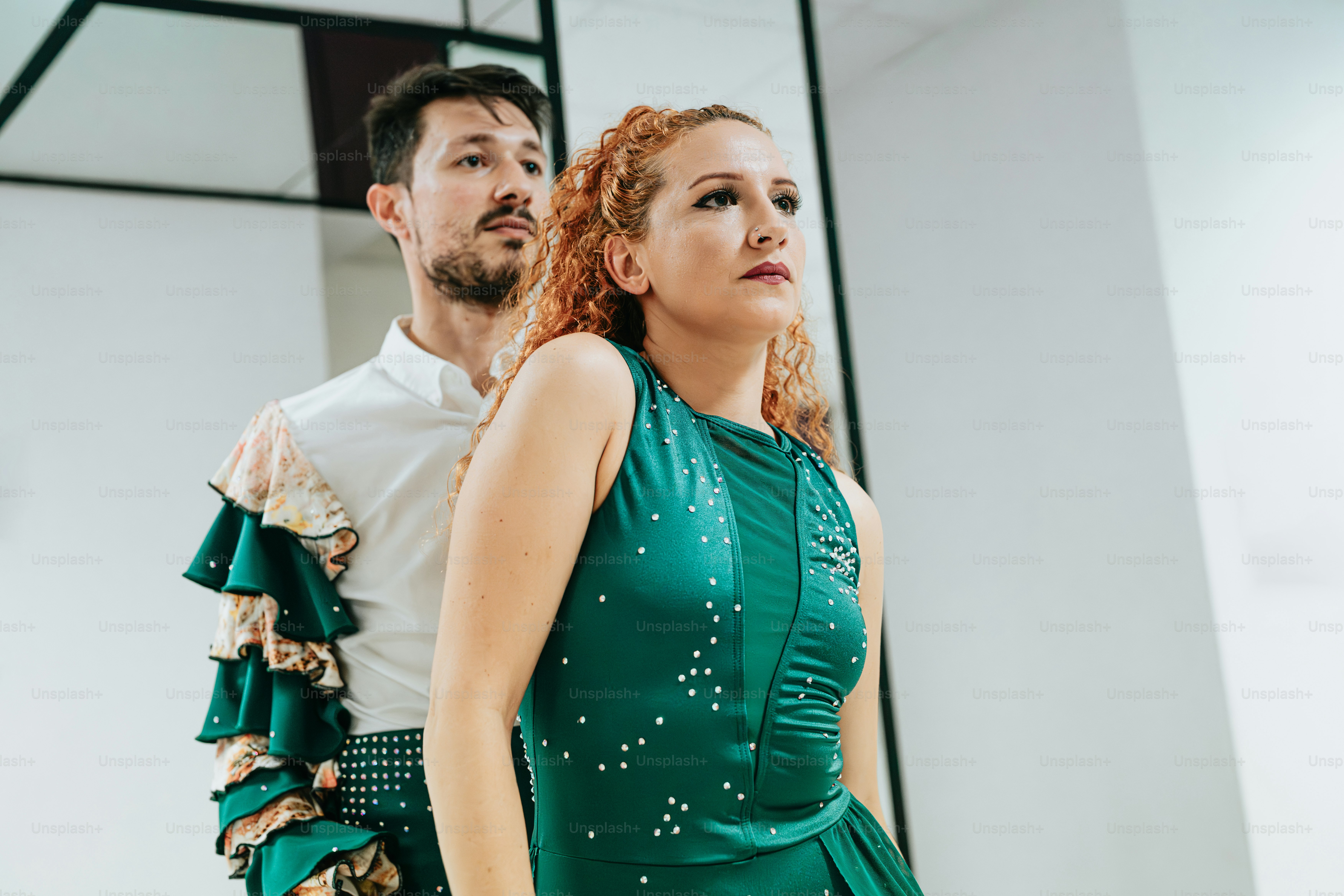 a man standing next to a woman in a green dress