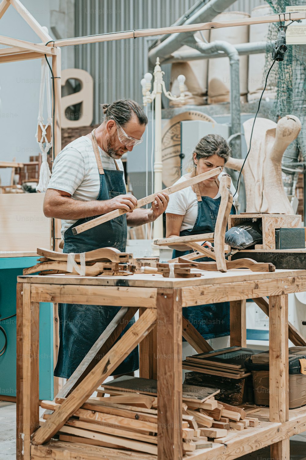 a man and a woman working on a piece of wood