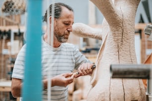 a man working on a sculpture in a shop