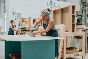 a woman working on a piece of furniture