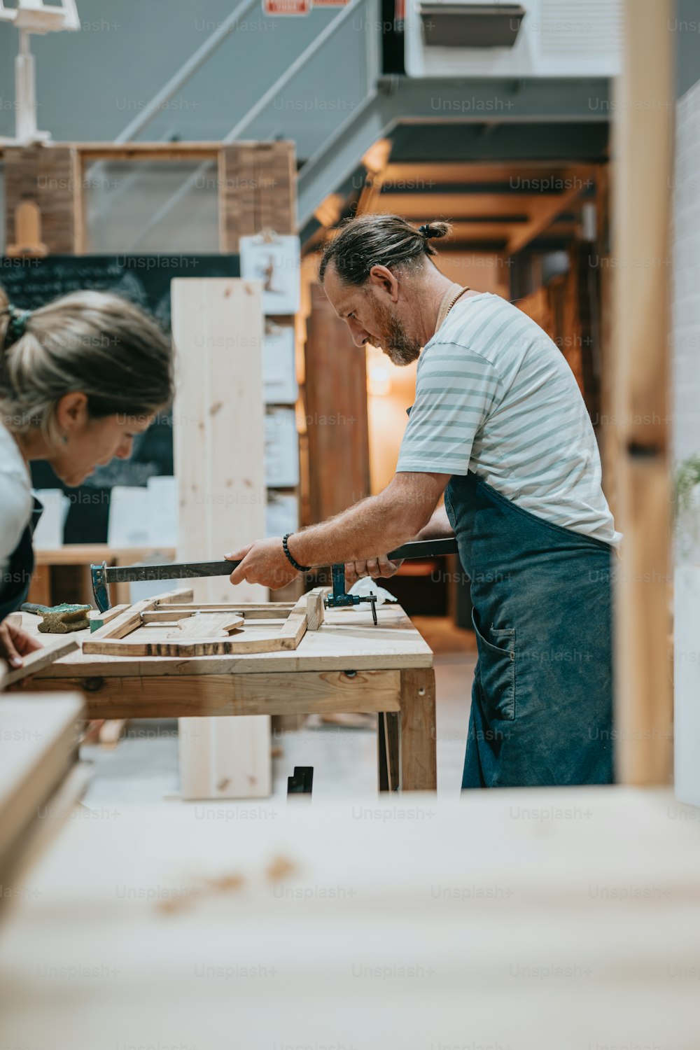 Un hombre y una mujer trabajando en un trozo de madera