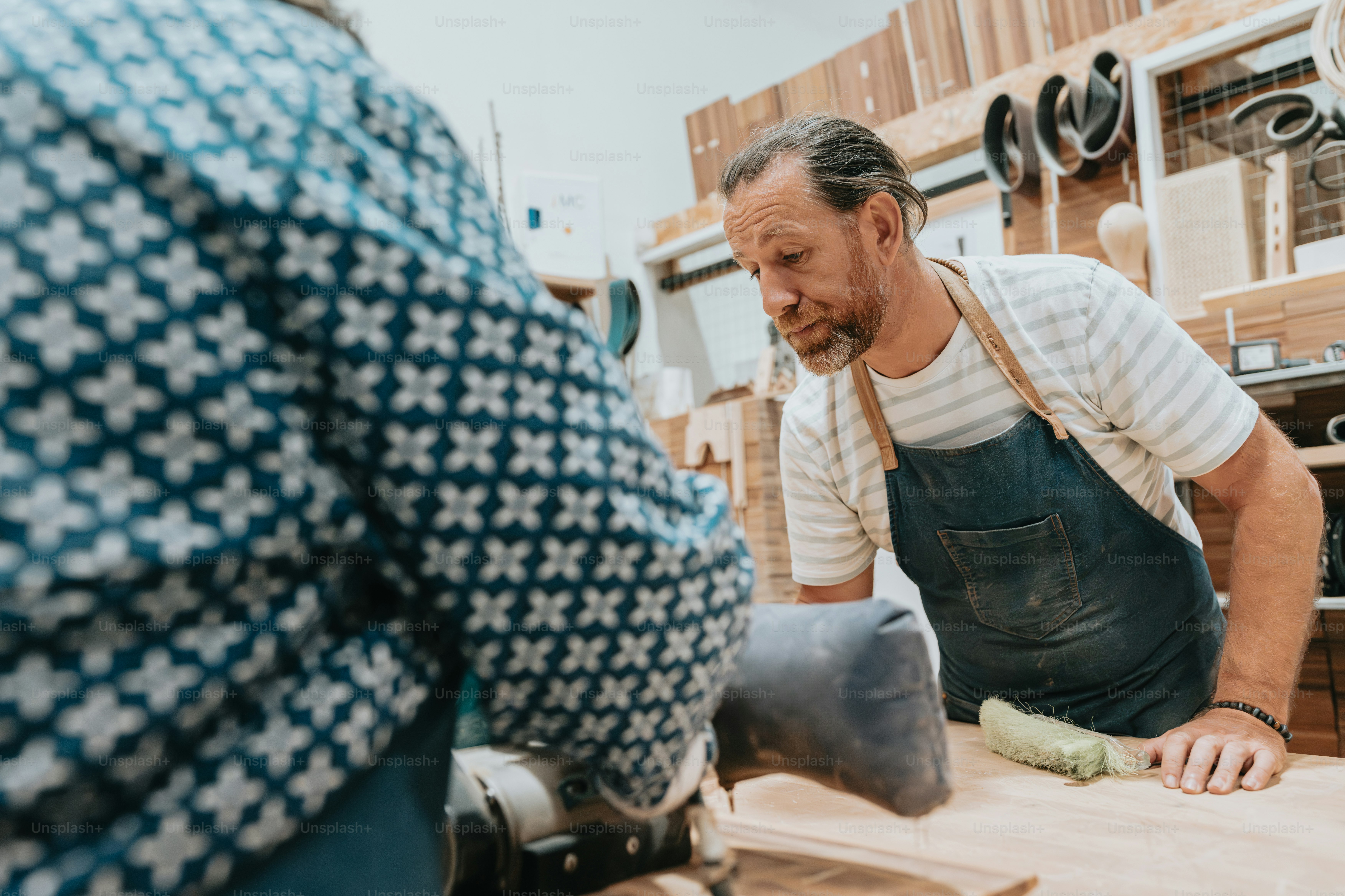 a man with an apron on working on a piece of wood