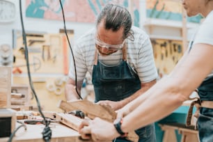 Zwei Männer, die an einem Stück Holz arbeiten