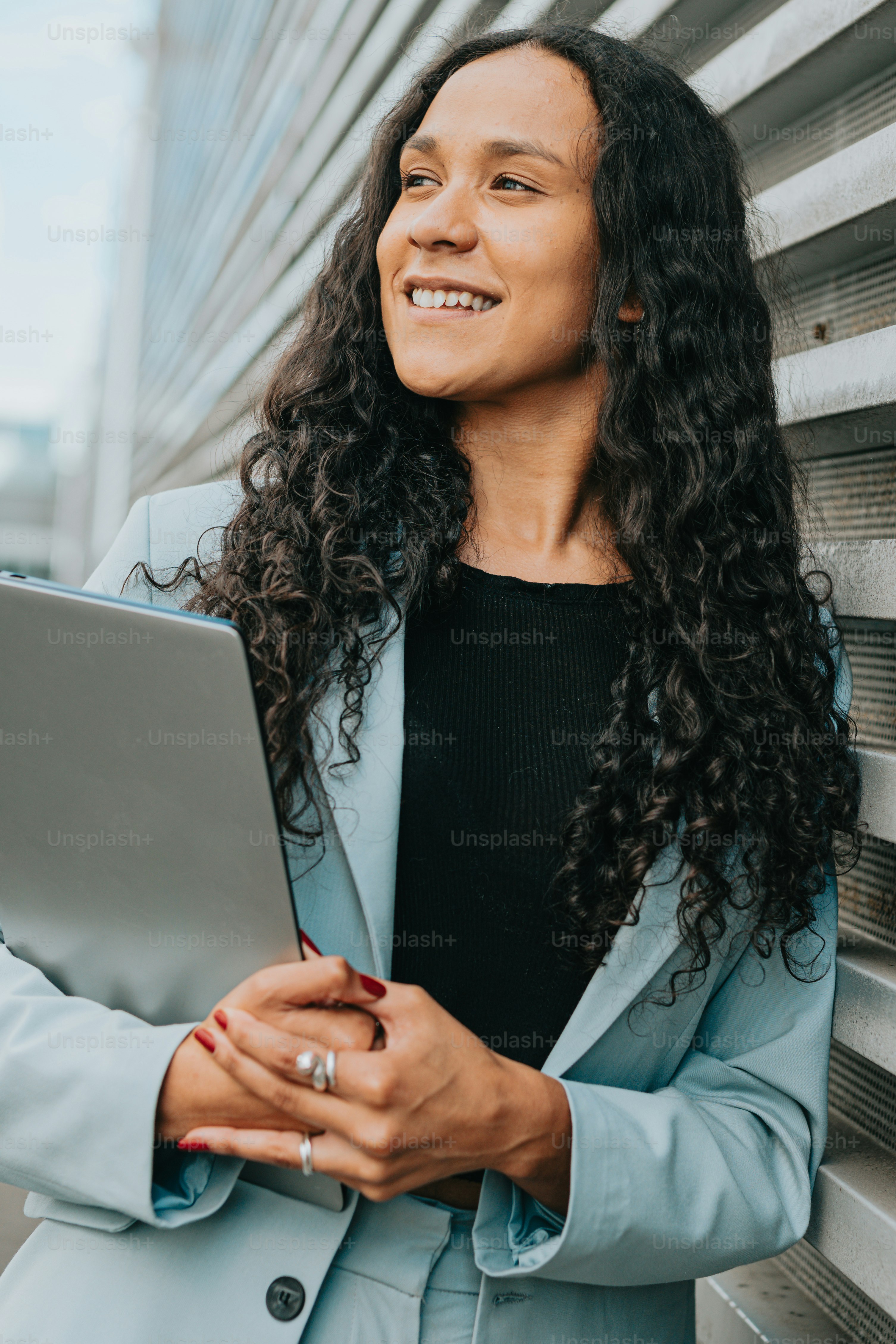 A woman in a blue coat holding a laptop photo – Woman Image on Unsplash
