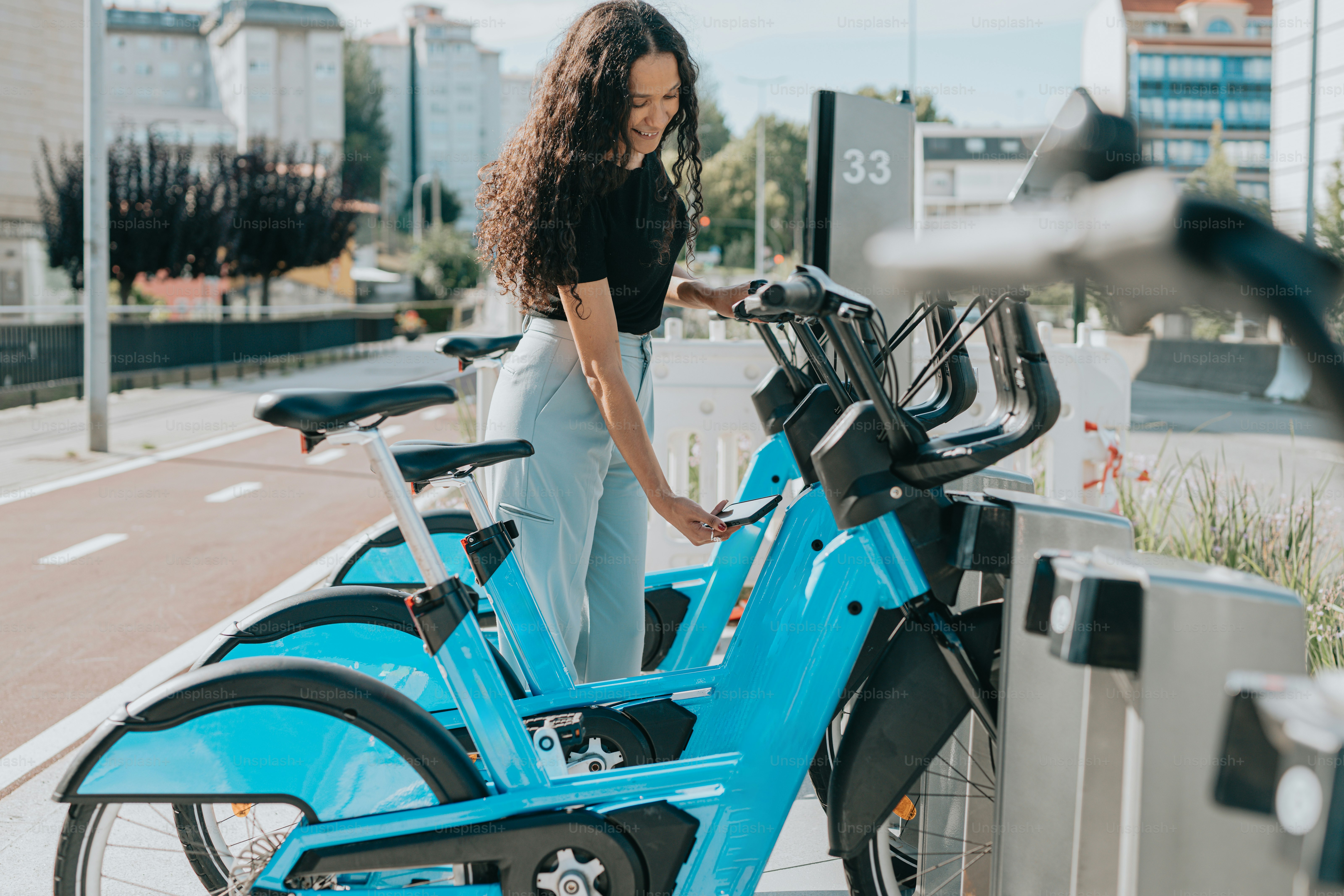 a woman standing next to a row of parked bicycles