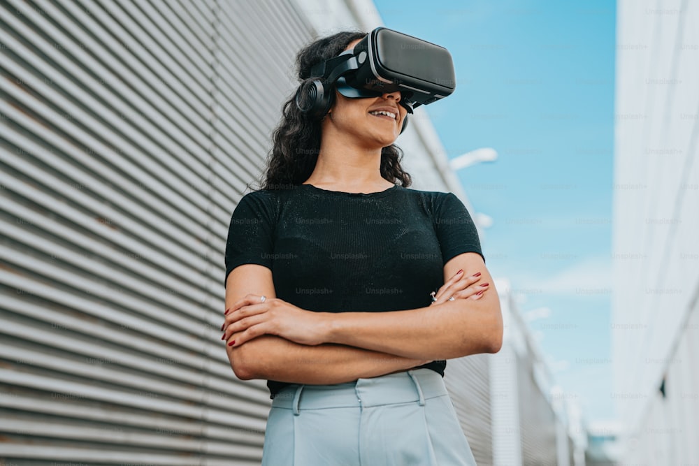 a woman standing in front of a building wearing a virtual reality headset