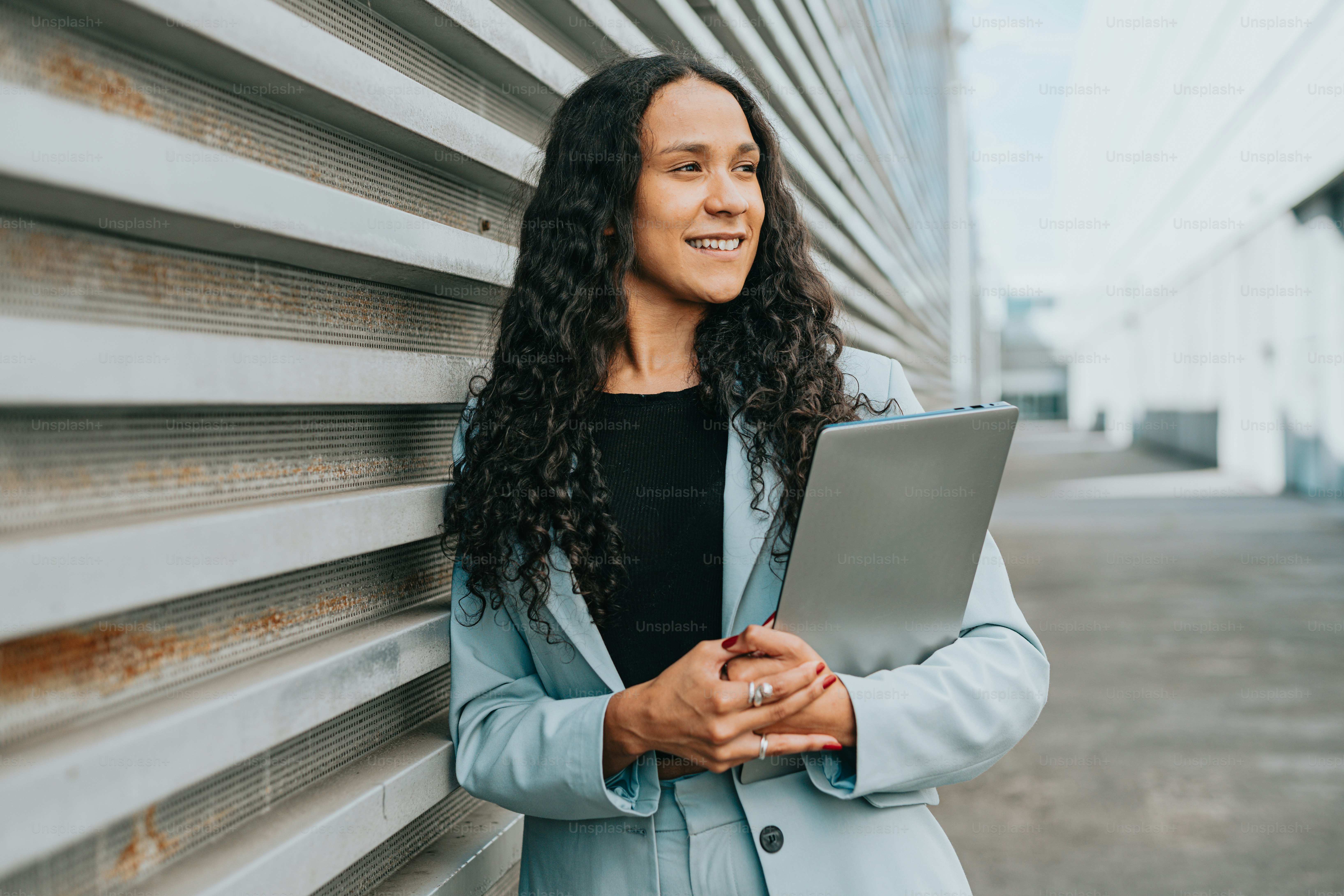 a woman standing next to a building holding a clipboard