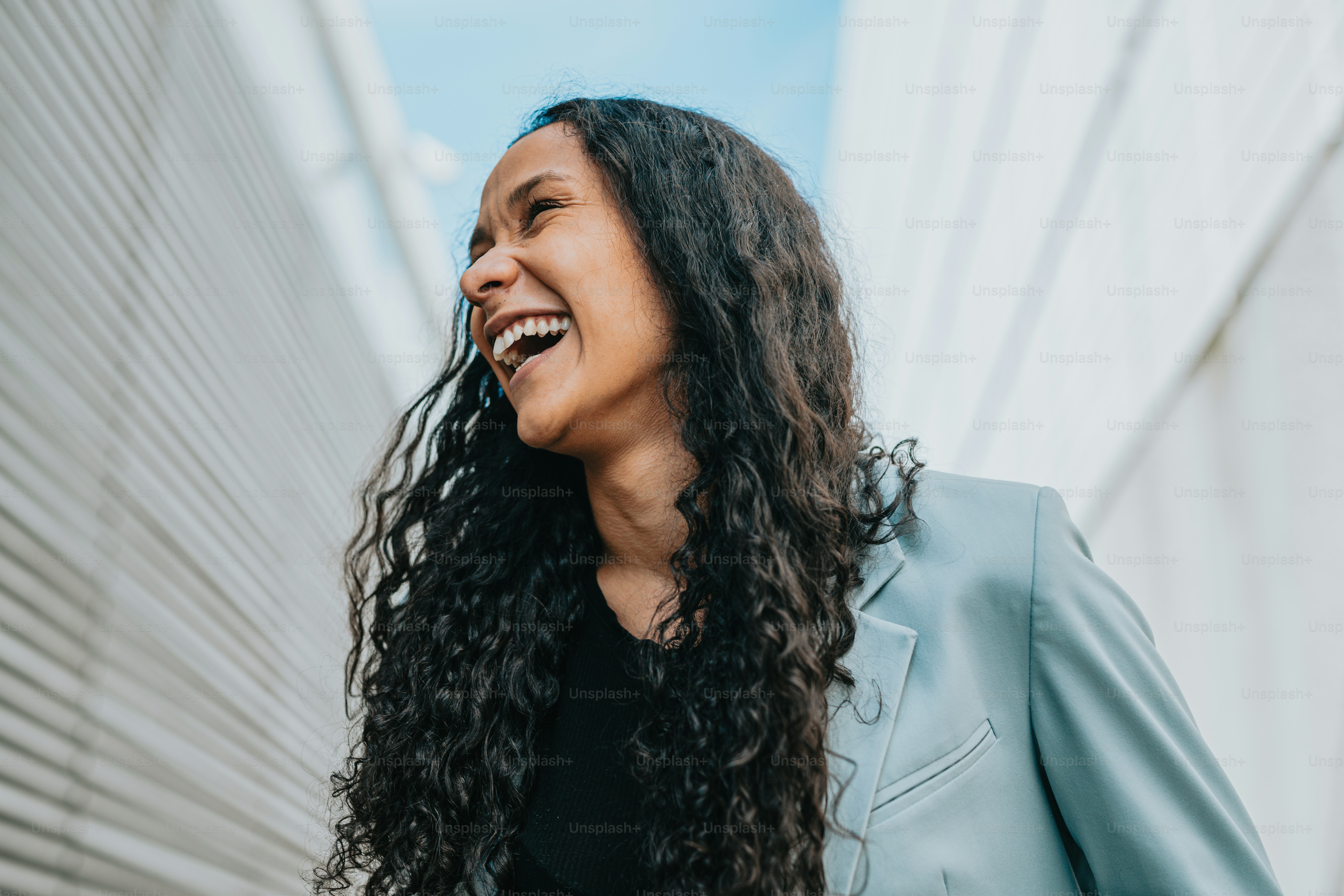 a woman with long curly hair smiling