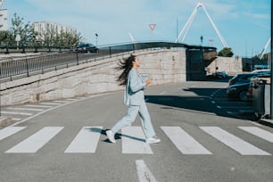 a woman in a blue suit crossing a street