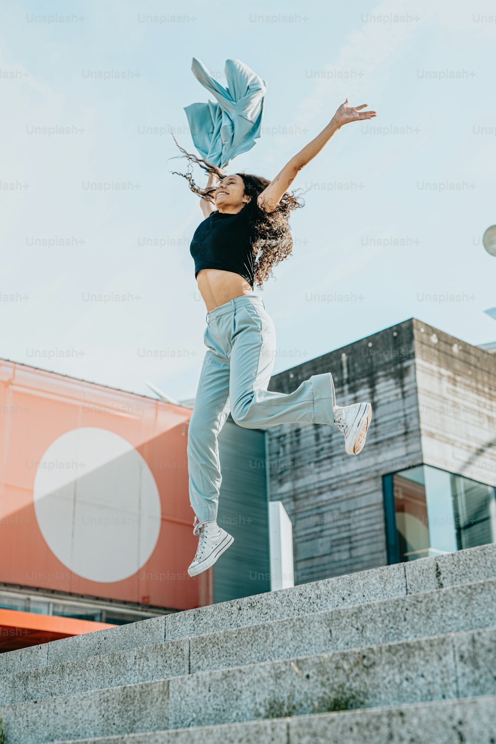 a woman jumping in the air with her arms in the air
