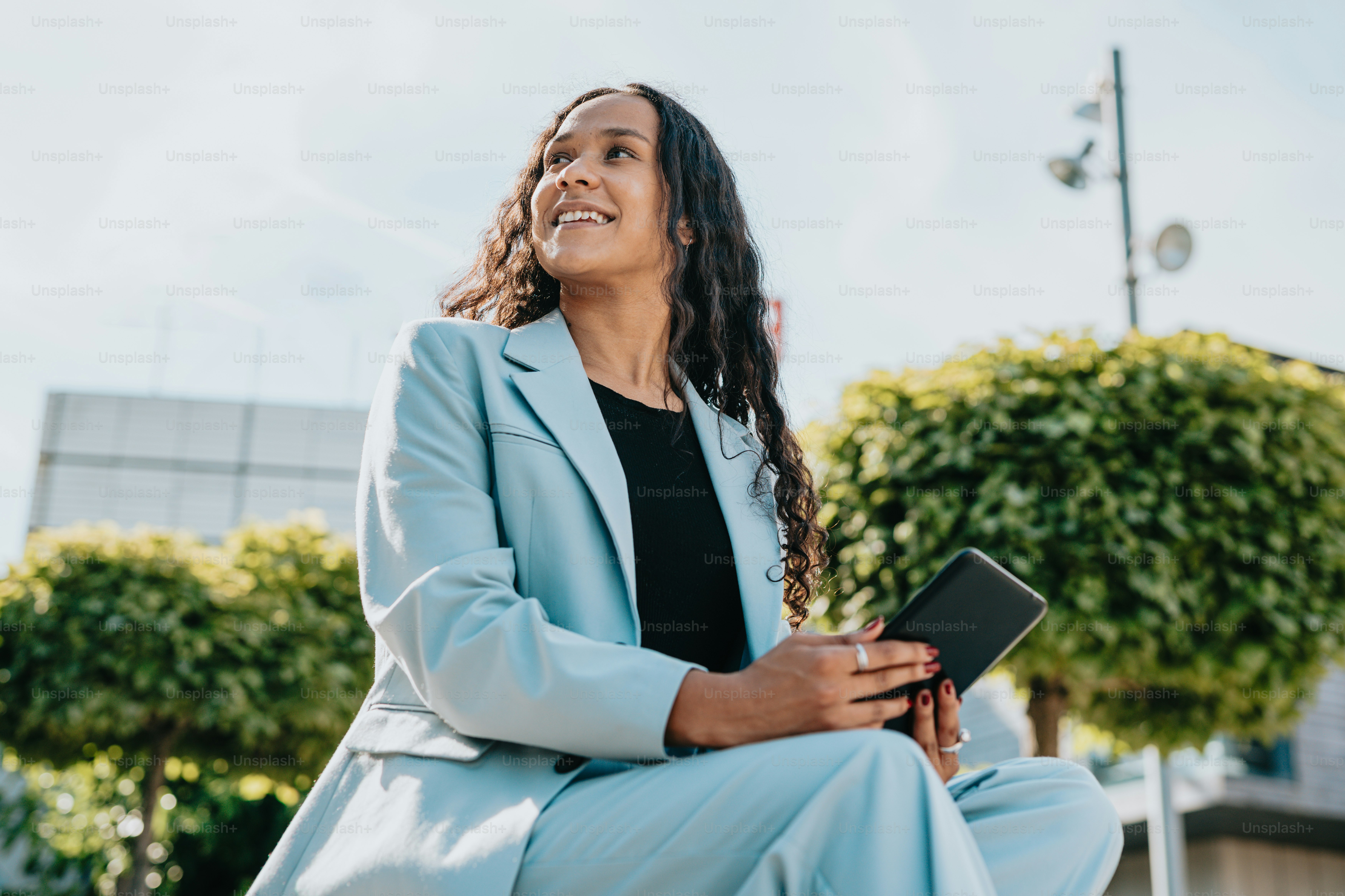 a woman in a blue suit sitting on a bench