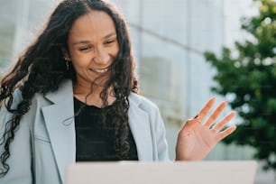 a woman holding her hand out in front of a laptop