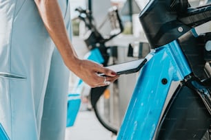 a person holding a cell phone next to a blue bike