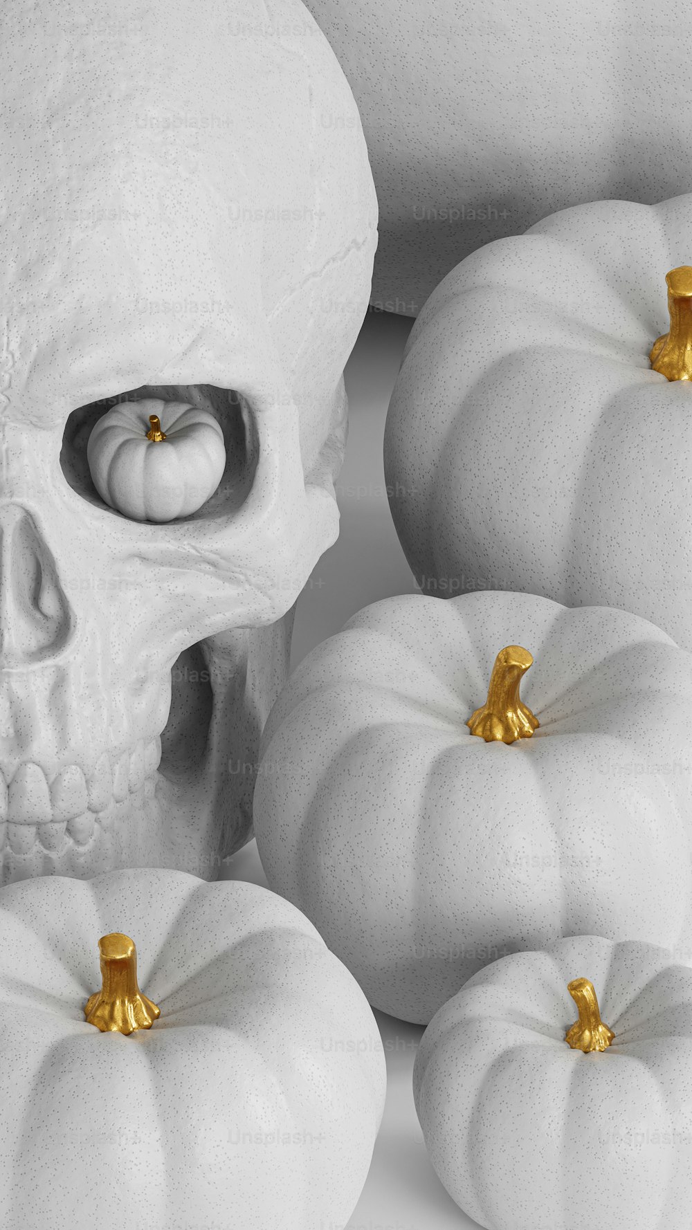 a group of white pumpkins with a skull in the middle