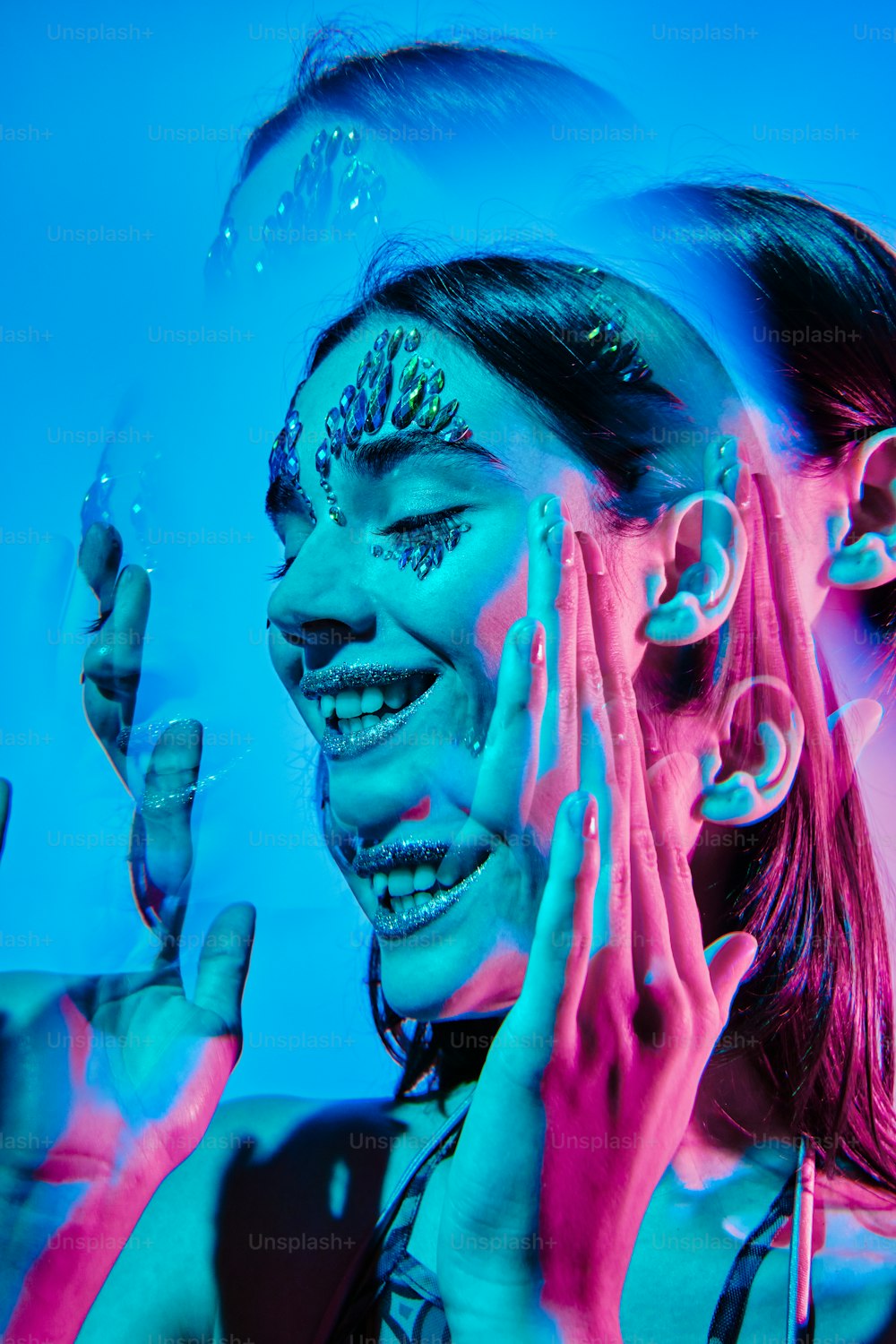a woman with face paint holding her hands up to her face