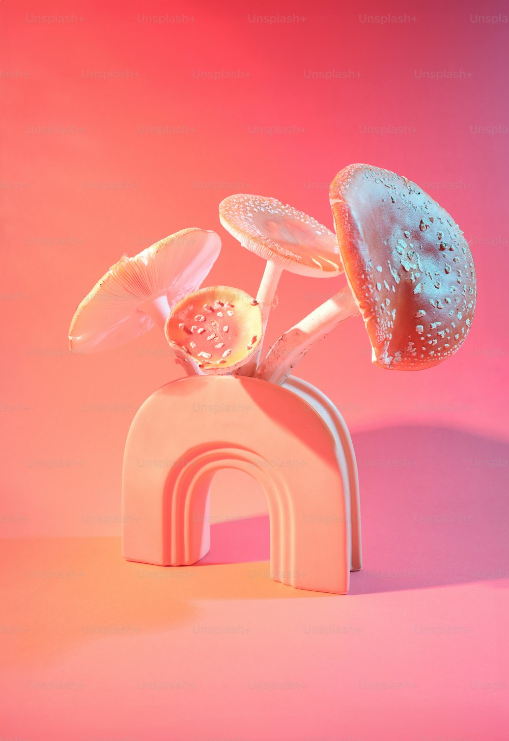 una scultura di funghi su uno sfondo rosa