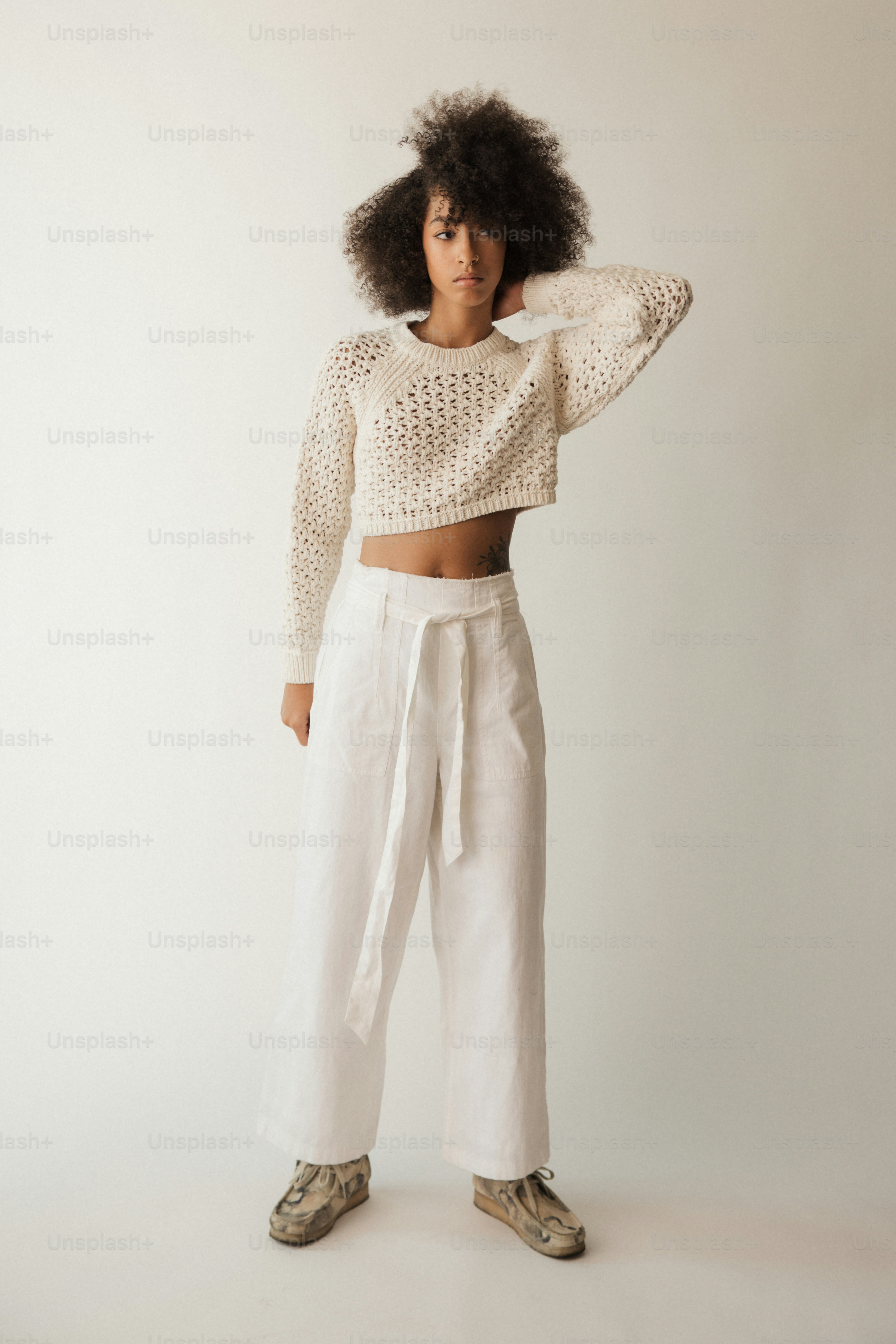 seorang wanita dengan celana putih dan crop top
