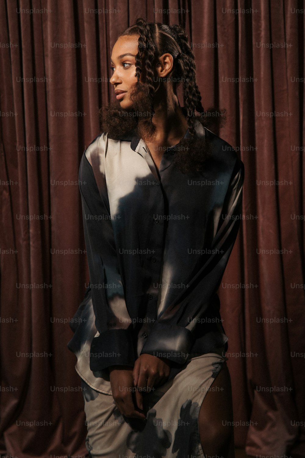 a man with dreadlocks sitting in front of a curtain