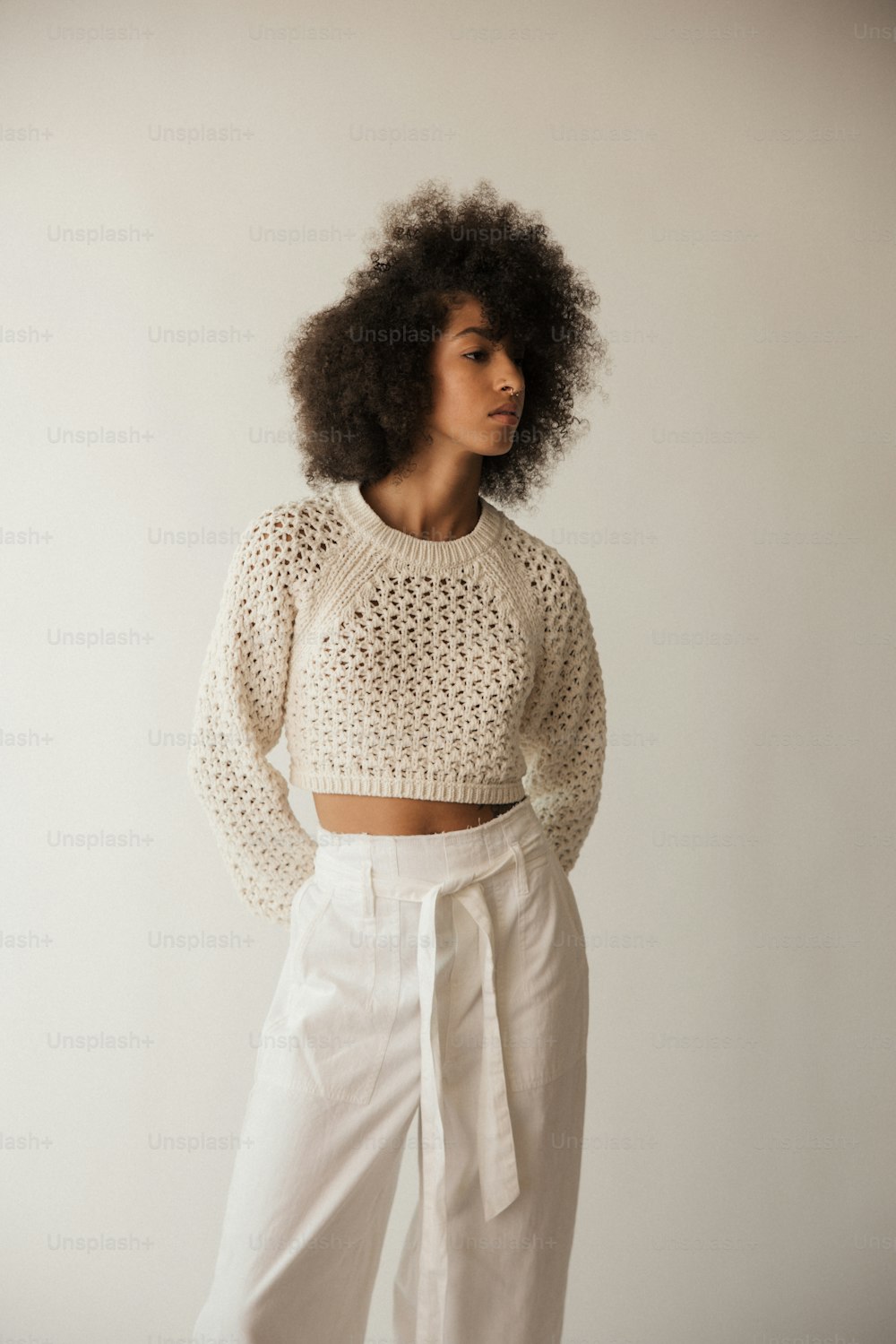 a woman in white pants and a cropped sweater