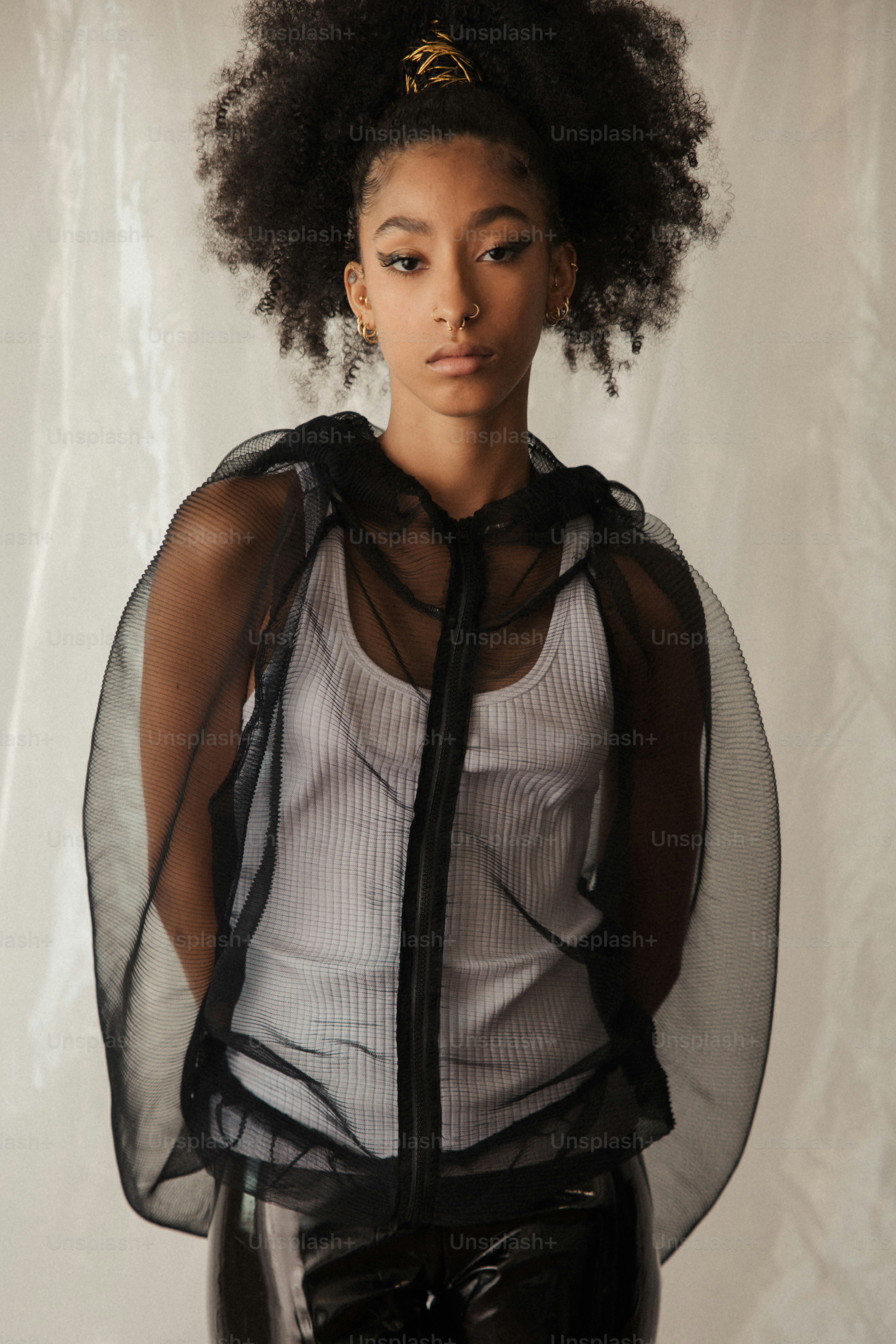 eine frau mit einem afro, die vor einem weißen hintergrund steht