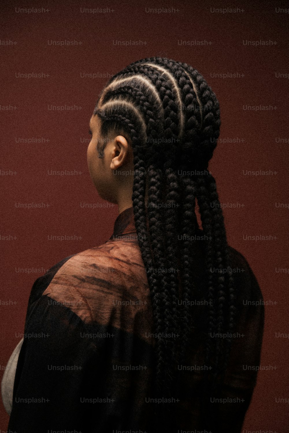 a woman with long cornrows and a black shirt