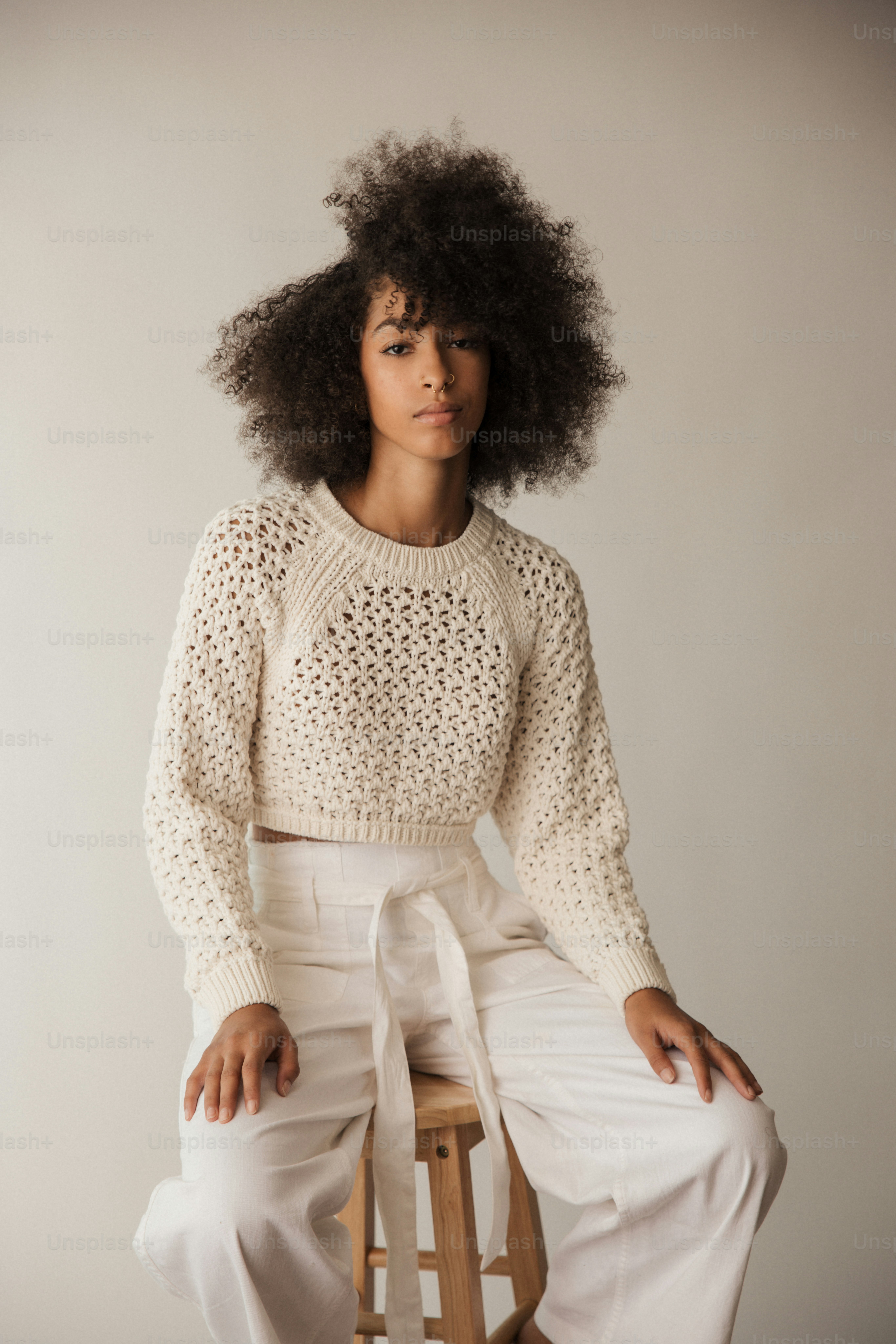 a woman sitting on top of a wooden stool