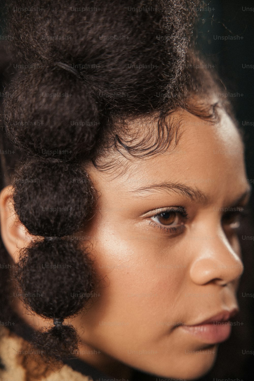 a close up of a person with a hair bun