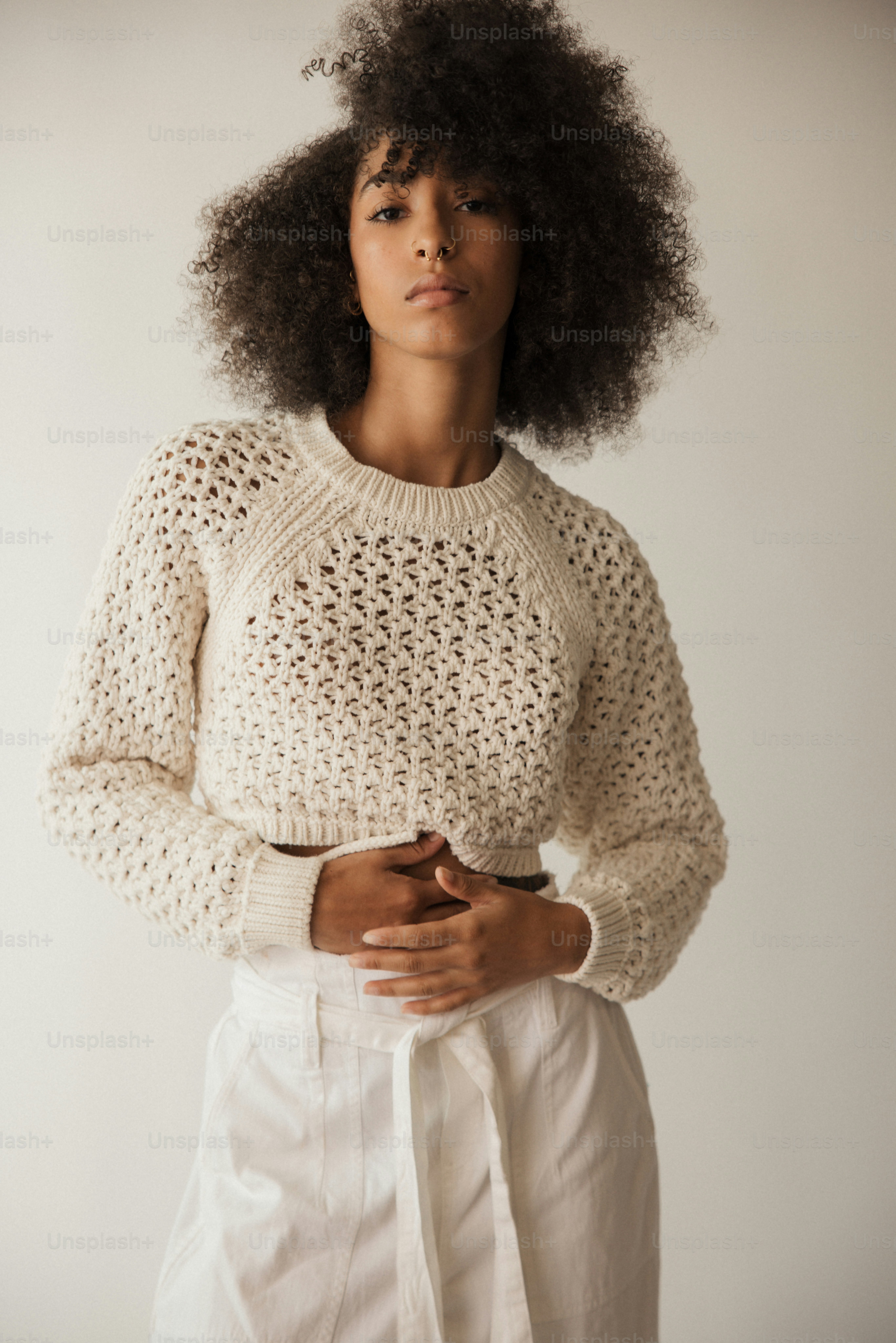 Une femme vêtue d’un pull blanc et d’un pantalon blanc