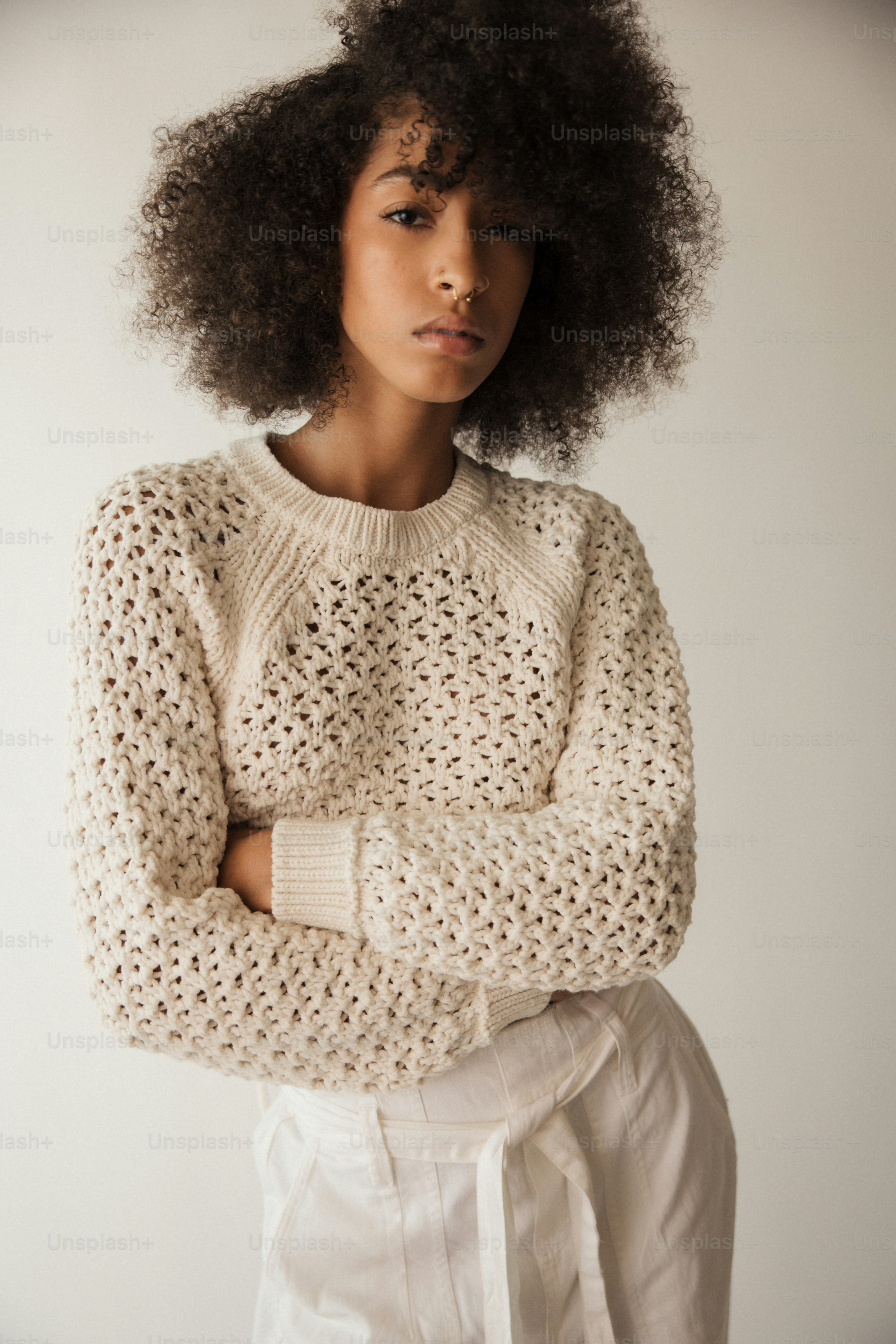 a woman with an afro standing with her arms crossed
