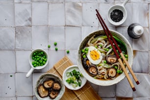 a bowl of noodles and mushrooms with chopsticks