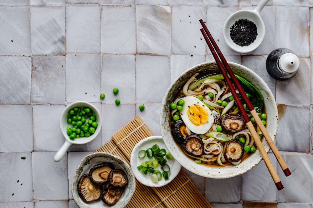 a bowl of noodles and mushrooms with chopsticks